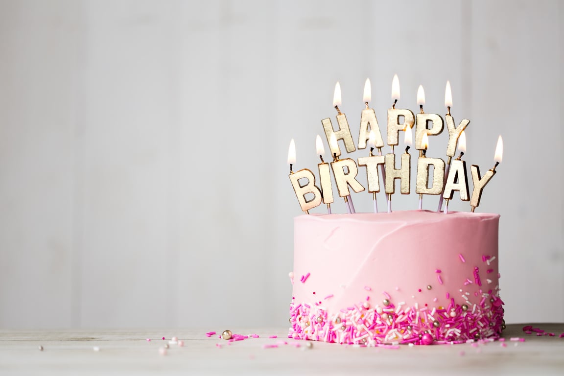 Pink birthday cake with happy birthday candles